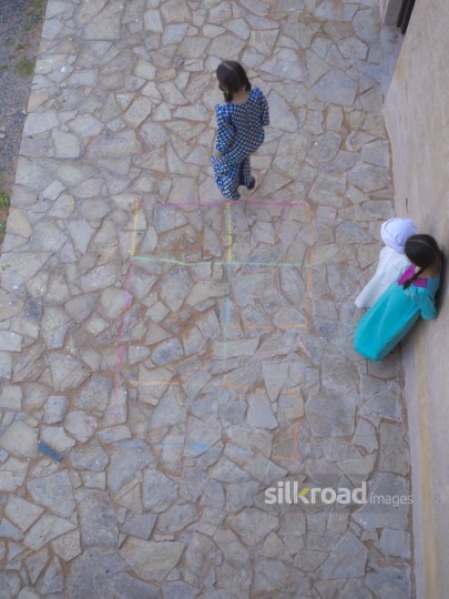 Kids playing hopscotch outside|-