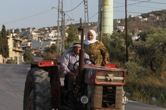 senior couple riding the tractor on the street