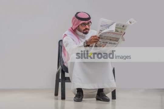 Arab man reading newspaper 