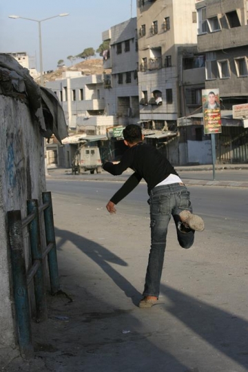 palestinian boy throwing stones at israeli military