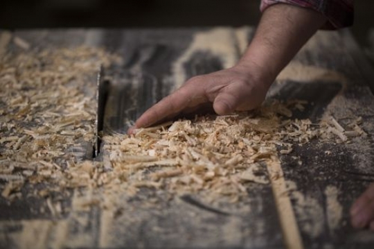 Man cleaning the dust from the wood
