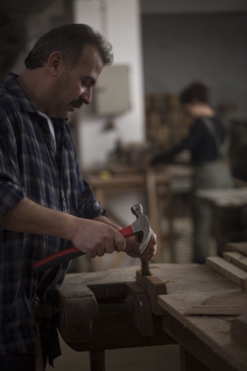 Worker using a hammer at the workshop