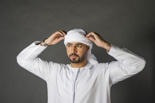 Man fixing his traditional attire