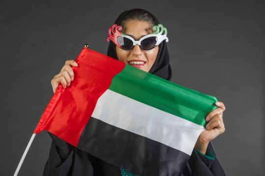 Arab woman carrying the UAE flag