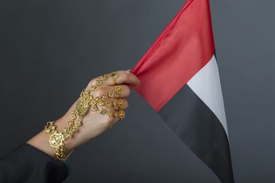 Close up of a woman carrying the UAE flag with her traditional jewellery