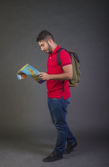 Arab man walking with a map in hand|-