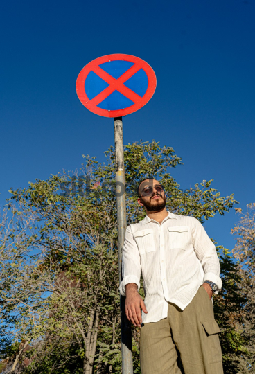 Stylish Man Standing by "Don't Allow" Sign at Sunset